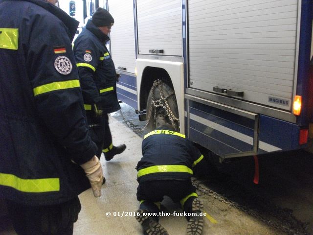 Auflegen von Gleitschutzketten auf die Einsatzfahrzeugen des THW