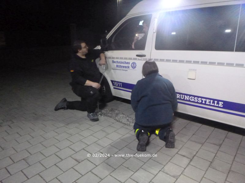 Einsatzkräfte beim Aufziehen der Gleitschutzketten